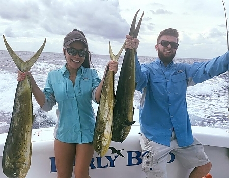 Young couple poses with their fish.