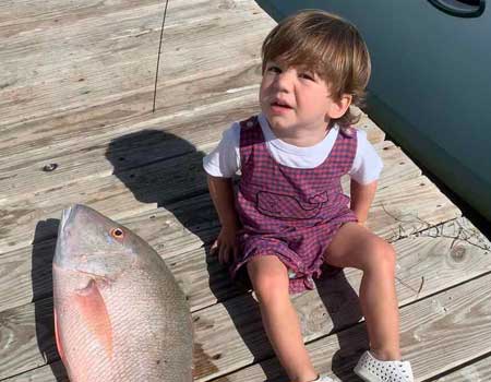 Young boy smiles with his fish