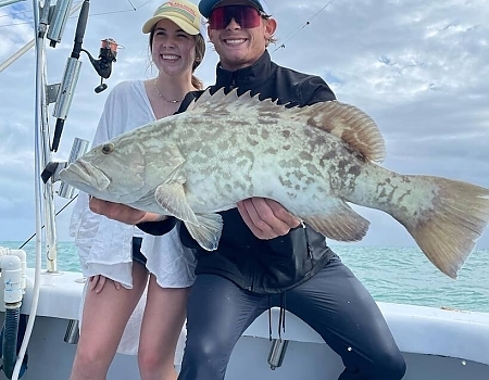 Young couple poses with their fish.