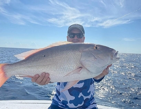 Man aboard boat holds up a huge fish