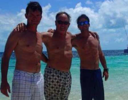  Three men pose on the beach