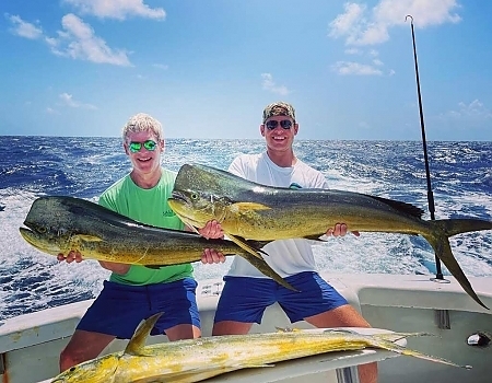 Man and child hold up fish caught